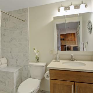 A modern bathroom with a sink, toilet, and shower area.