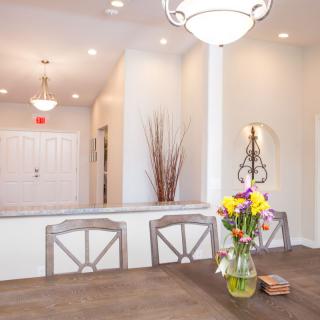 A bright and modern dining room with a table, chairs, and a vase of flowers.