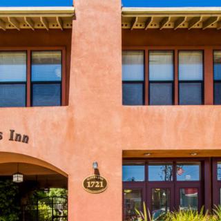 Two-story inn with a warm, welcoming facade and large windows.