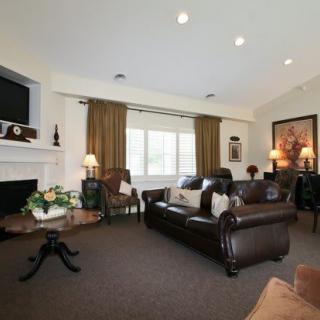A cozy living room with leather sofas, a fireplace, and a television.