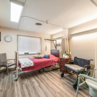 An empty hospital room featuring a patient bed and wheelchair.