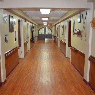 A well-decorated hallway with a wooden floor and various decorative items on the walls.