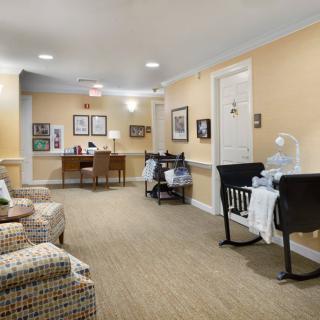 A cozy lobby area featuring comfortable seating and a small desk in a warmly lit hallway.