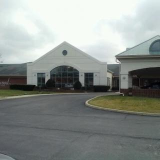 A modern architectural building with a prominent entrance on a cloudy day.
