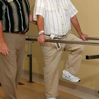 A man undergoing physical therapy with the assistance of a therapist.