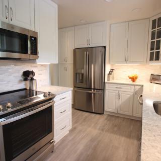 A modern kitchen with stainless steel appliances and white cabinets.