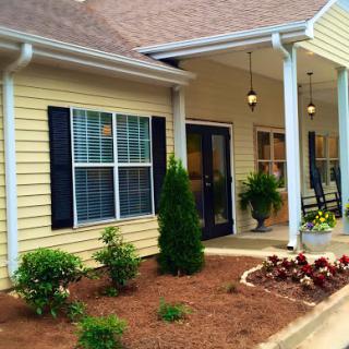 A charming house exterior with a welcoming porch and well-maintained garden.