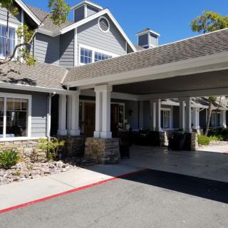 A large residential house with a covered entrance and driveway.