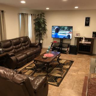A cozy living room with leather sofas, a coffee table, and a television.