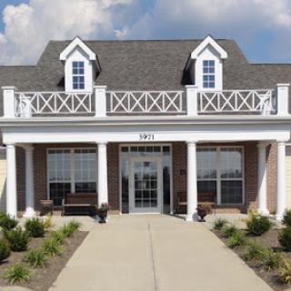 A charming two-story building with a welcoming front entrance and beautiful landscaping.