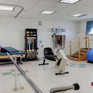 A physical therapy room equipped with various exercise machines and rehabilitation tools.