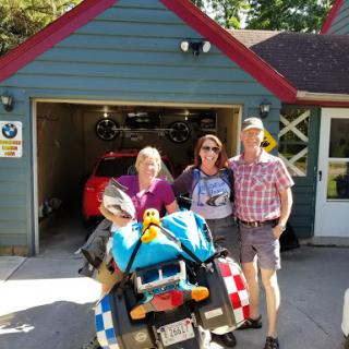 A fun day with friends in front of a colorful garage, ready for an adventure on the motorcycle.