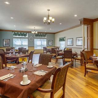 A well-arranged dining room with elegant table settings and a chandelier.