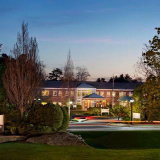 A well-lit building surrounded by trees during the evening.