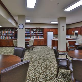 A cozy library with bookshelves, tables, and chairs for reading and studying.