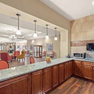 A modern kitchen with granite countertops and a view into a dining area.