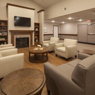 A modern lobby with comfortable seating, a fireplace, and a wall-mounted television.