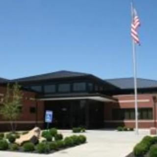 A school building with an American flag flying in front.