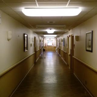 A long corridor with bright lighting and doors lining the walls.