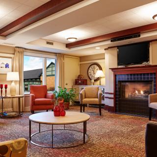 A cozy living room featuring a fireplace, comfortable armchairs, and elegant decor.