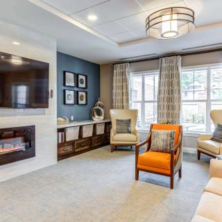 A modern living room with elegant decor, featuring a wall-mounted television and a cozy fireplace.