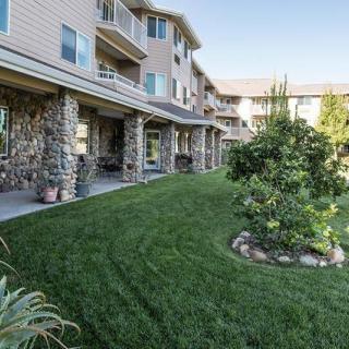 A well-maintained lawn and garden area in front of a residential apartment building.