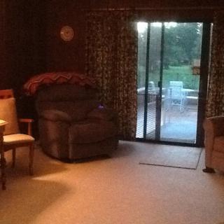 A cozy living room with an armchair and sliding glass doors leading to a patio.