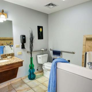 A clean and well-decorated bathroom with a toilet, sink, and mirror.