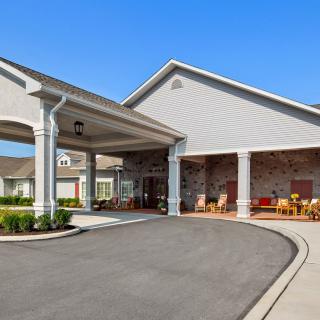 A residential building with a covered entrance and driveway.