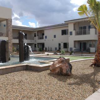 A courtyard with a fountain and landscaping in an apartment complex.