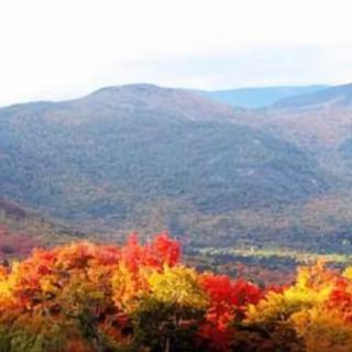 A beautiful landscape of mountains with vibrant autumn foliage.