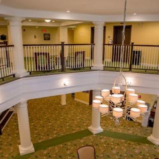 A beautifully designed lobby featuring a stunning chandelier and elegant columns, creating a spacious and inviting atmosphere.