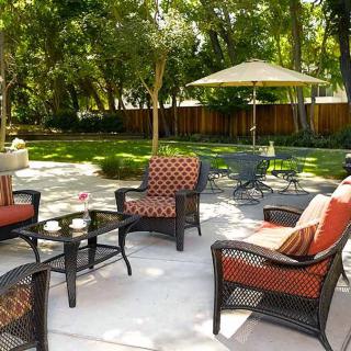 A cozy patio setup with wicker furniture and a garden view.
