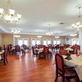 An elegant dining room with neatly arranged tables and chandeliers.