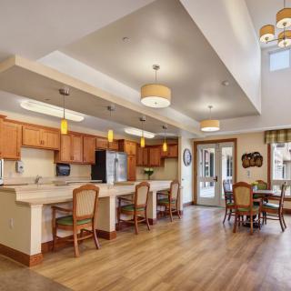 A modern, open kitchen and dining area featuring wooden flooring and stylish lighting.