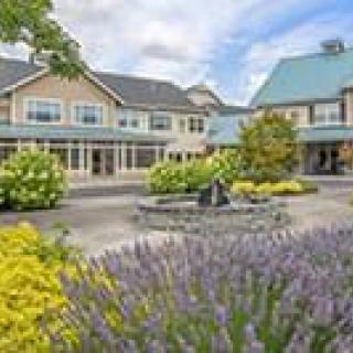 A scenic view of a building with a landscaped garden and flowers in the courtyard.