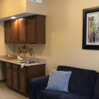 A cozy living space with a small kitchenette and comfortable seating.