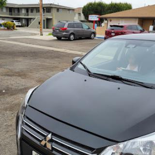 A Mitsubishi car parked in an urban area near several buildings.