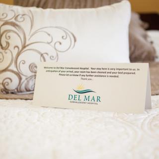 A welcoming note on a bed, showcasing hospitality in a hotel room with stylish decor.