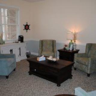 A cozy living room with armchairs and a coffee table.
