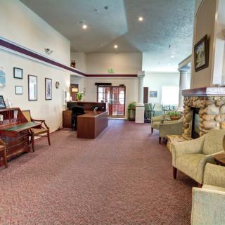 A spacious lobby with seating, a piano, and a fireplace.