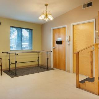 A physical therapy room featuring parallel bars for rehabilitation exercises.