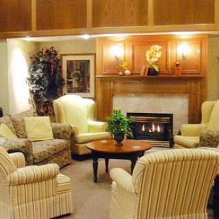 A cozy living room with a fireplace surrounded by comfortable chairs and elegant decor.