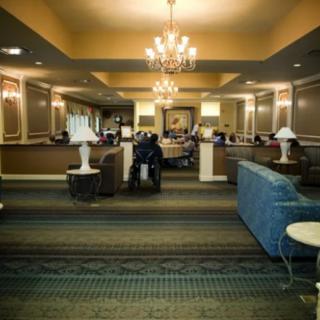 A well-lit lobby featuring elegant chandeliers, comfortable seating arrangements, and decorative furnishings.