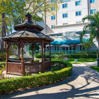 A scenic outdoor garden area with a gazebo in front of a hospital.