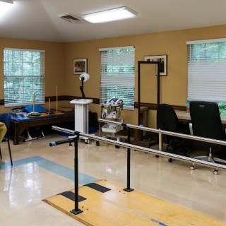 A well-equipped physical therapy room featuring balancing bars and various rehabilitation tools.