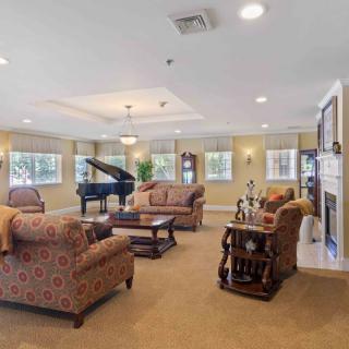 A spacious living room featuring elegant furniture, a grand piano, and a cozy fireplace.