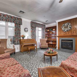 A cozy living room features a piano, fireplace, and comfortable seating arrangement.