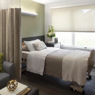 A modern and comfortable hospital room with a neatly made bed and elegant decor.