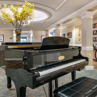 A luxurious music room featuring a grand piano and elegant decor.